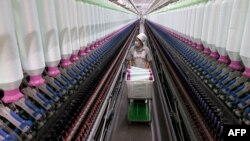 中国山东枣庄市一家纺织业工厂的工人在生产线上。(2024年12月15日)