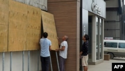 当地人在热带龙卷风哈罗德登录瓦努阿图首都维拉港前在商店门口假设防护板。(2020年4月6日)