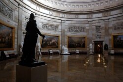 FILE - A statue of President George Washington looks over an empty Capitol Rotunda, on Capitol Hill in Washington, April 9, 2020.