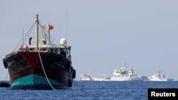 中国一艘渔船2017年4月5日停泊在南中国海的黄岩岛附近,旁边是中国的海警船。
