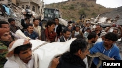 人们抬走一具在空袭炸毁的房屋废墟下发现的女性尸体。(2017年8月25日)