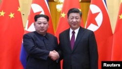 中国国家主席习近平和朝鲜领导人金正恩在北京人民大会堂握手(2018年3月28日发布的照片)