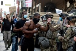 Demonstrators greet members of the National Guard as they march along Hollywood Boulevard, Tuesday, June 2, 2020, in the Hollywood section of Los Angeles.