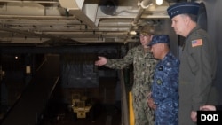 驻日美军司令马丁内斯空军中将(右)陪同日本海上自卫队官员参观美国海军日耳曼城号登陆舰