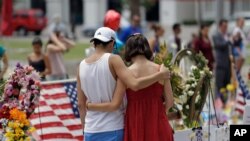 2016年6月20日,一对年轻人在佛罗里达奥兰多市为夜店枪击事件中遇难者静默哀悼。