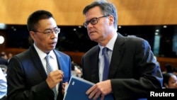 美国驻WTO大使谢伊(右)在瑞士日内瓦举行的世界贸易组织(WTO)会议上与中国驻WTO大使张向晨交谈。(2018年7月26日)
