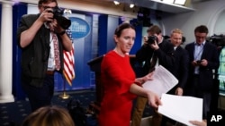 白宫副新闻秘书林赛·沃尔特斯在白宫新闻室向记者发放资料。(2017年5月9日)