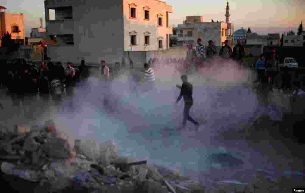 Cư dân tìm kiếm người sống sót sau một vụ pháo kích của lực lượng chính phủ Syria tại thành phố Azaz, phía bắc Aleppo, ngày 29/12/2012.