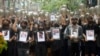 Anti-coup protesters holding pictures of those who died during a protest against the military offer prayers for them, in Yangon, Myanmar, Monday, April 5, 2021. Threats of lethal violence and arrests of protesters have failed to suppress daily demonstrations across Myanmar demand