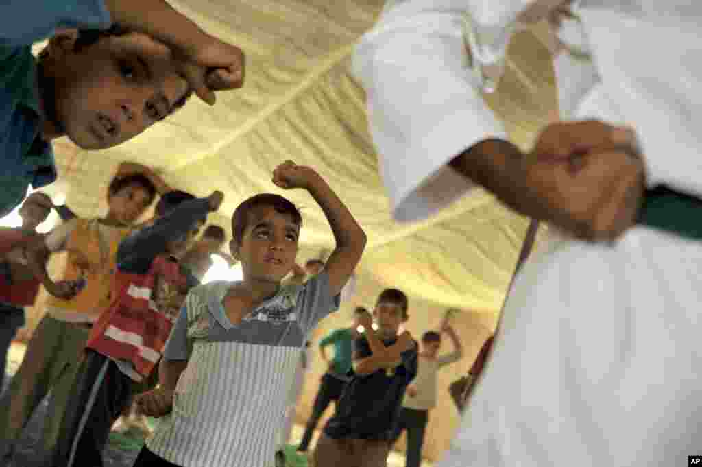 Syrian refugee children look at their Korean taekwondo instructor at Zaatari refugee camp near Mafraq, Jordan, Sept. 17, 2013.