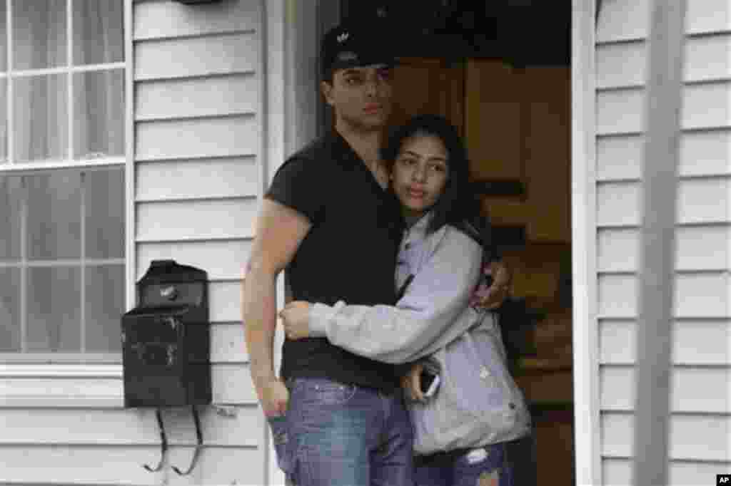 Cư dân quan sát các nhân viên công lực đi lục soát khắp khu vực để tìm nghi can còn sống đang ẩn núp.