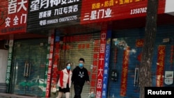 中国封城封路中的店铺关了,街上行人稀少,戴口罩者匆匆赶路