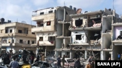 叙利亚官方通讯社发布的图片显示,叙利亚人聚集在霍姆斯发生两起爆炸的地点(2016年2月21日)