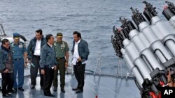 Presiden Joko Widodo didampingi Sekretaris Kabinet Pramono Anung, KSAL Laksamana Ade Supandi, dan Menko Polhukam Luhut Pandjaitan, Panglima TNI Gatot Nurmantyo dan Gubernur Kepri Nurdin Basirun, berada di KRI Imam Bonjol di perairan Natuna, 23 Juni 2016. (Foto: Agus Suparto/AP)