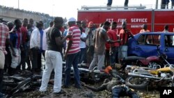 人们聚集在尼日利亚阿布贾一处汽车站的爆炸现场。(2014年4月14日)