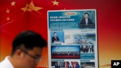 资料照片:一名男子经过北京一家地铁站张贴的中国一带一路倡议的广告。(2018年8月28日)