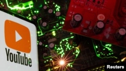 Foto ilustrasi yang menunjukkan logo YouTube yang tersemat pada sebuah layar smartphone yang berada di samping motherboard sebuah komputer. (Foto: Reuters/Dado Ruvic)