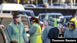 Medical workers administer tests at the Bondi Beach drive-thru coronavirus disease (COVID-19) testing center in the wake of new positive cases in Sydney, Australia, June 17, 2021.