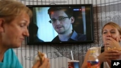 Tin tức về Edward Snowden tại một quán cà phê trong sân bay Sheremetyevo ở Moscow, ngày 26/6/2013. Ông Snowden bị Hoa Kỳ truy nã vì đã tiết lộ một số tin tức tối mật về chương trình theo dõi của Hoa Kỳ