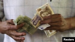 北京一处市场的一名顾客在点算人民币。(2015年8月12日)