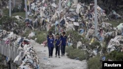 နီပေါနိုင်ငံ၊ ကတ်မန်ဒူမြို့က ပလပ်စတစ်အမှိုက်ပုံတွေကြား သွားလာနေတဲ့ ကျောင်းသူများ၊ အောက်တိုဘာ ၂ , ၂၀၂၄။