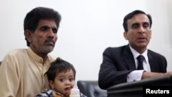 Bé Musa Khan 9 tháng tuổi được người ông bế ra tòa ở Lahore, ngày 12/4/2014.