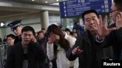 失踪马航班机MH370上的乘客亲属在北京首都机场焦急和哀伤地等待亲人消息。(2014年3月8日)
