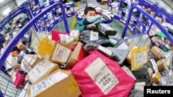 中国河北省秦皇岛市一名戴着口罩的工人在中国邮政的一个物流中心处理包裹。(2020年2月24日)