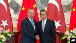 中国外长王毅和土耳其外长查武什奥卢在北京钓鱼台国宾馆举行了联合记者会后握手。(2017年8月3日)