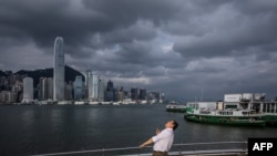 一名男子在香港维多利亚港的海滨长廊上抬头仰望,超强台风 “摩羯”(Yagi)正向中国南部沿海移动。(2024年9月5日)