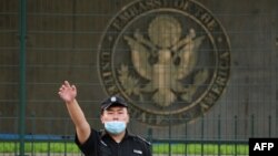 资料照片:美国驻北京大使馆外的一名中国保安在做手势。（2020年9月12日）