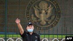 美国驻北京大使馆外的一名中国保安在做手势。（2020年9月12日）