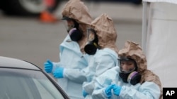 美国科罗拉多国民警卫队医疗人员在丹佛一个“得来速”(drive-through)检疫站为民众做新冠病毒检测。(2020年3月14日)