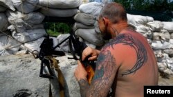 Dân quân thân Nga canh gác tại một chốt kiểm soát trong khu vực ngoại ô của thị trấn phía đông Slaviansk ở Ukraina, ngày 19/5/2014.