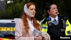 Một phụ nữ bị thương được đưa ra khỏi hiện trường tại trạm xe điện ngầm Parsons Green ở London, Anh, ngày 15/9/17.