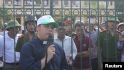 越南一位天主教神父同在法院外准备起诉台塑河静钢厂的渔民交谈(2016年9月26日)