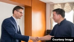 2018年8月7日,中共中央对外联络部副部长郭业洲(右)会见康明凯。(图片来源:中共中央对外联络部官网)