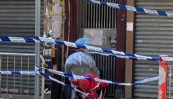 香港當局派駐人員看守封鎖區內的大廈出入口,禁止居民隨便出入。(美國之音 湯惠芸拍攝)