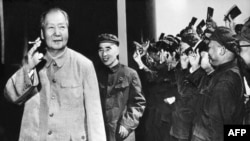 历史照片:中共最高领导人毛泽东(1893-1976)拿着烟卷,林彪紧随其后,其他人挥动着《毛主席语录》。(1970年9月初)