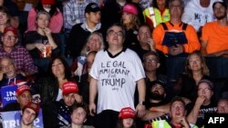 2024年11月5日,美国当选总统特朗普的支持者在密歇根州大急流城范安德尔体育场举行的竞选集会上穿着写有“合法移民支持特朗普”的T恤衫。