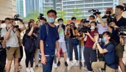 民主派初选47人案其中一名被告、黄大仙区议员施德来到法庭应讯时被记者包围拍照 (美国之音/汤惠芸)