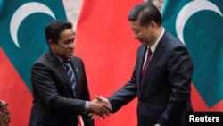 前马尔代夫总统阿卜杜拉·亚明与中国国家主席习近平在北京人大会堂的一个签字仪式上握手。(2017年12月7日)