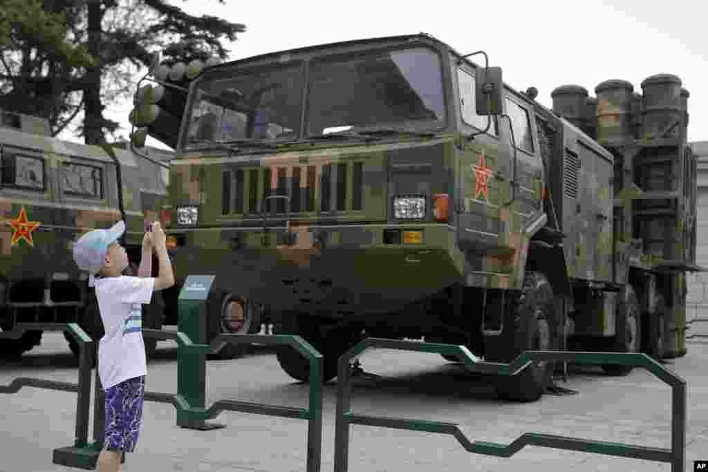 在北京军事博物馆,儿童给中程防空导弹发射器和运载车拍照(2017年7月27日)。为纪念中国人民解放军(People's Liberation Army)建军90周年,北京军事博物馆展览了一些新式武器。