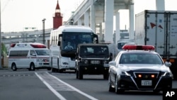 一辆据信载有钻石公主号游轮乘客的大巴车在警车开道下离开日本横滨港。(2020年2月19日)