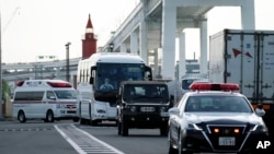 一辆据信载有钻石公主号游轮乘客的大巴车在警车开道下离开日本横滨港。(2020年2月19日)