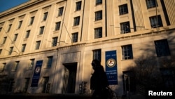 资料照片:一名女子走过位于华盛顿的美国司法部大楼。(2020年12月15日)
