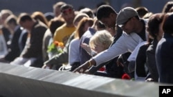 受难者家属2012年9月11日在纽约纪念911 恐怖分子袭击纽约世贸中心11周年之际,观看铭刻在纪念台上受难者的姓名