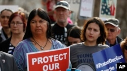 美国科罗拉多州参议院民主党籍参议员艾琳·阿吉拉尔(左)与平价医疗法案支持者一起参加抗议活动,反对废除这一法案。