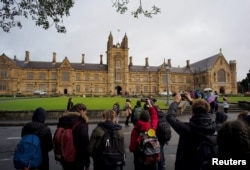 资料照:参观者在澳大利亚悉尼大学主楼前拍照。(2016年8月5日)