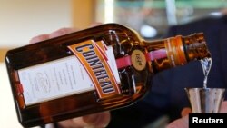 资料照:一人在法国干邑的白兰地酒厂里将人头马君度倒入玻璃杯中。(2018年11月21日)